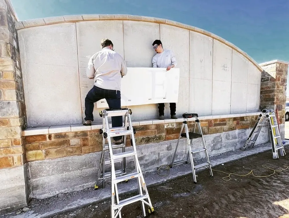 Two volunteers installing a wall panel